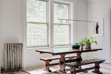 Пример оригинального дизайна: кухня-столовая в стиле неоклассика (современная классика) с белыми стенами, деревянным полом и белым полом