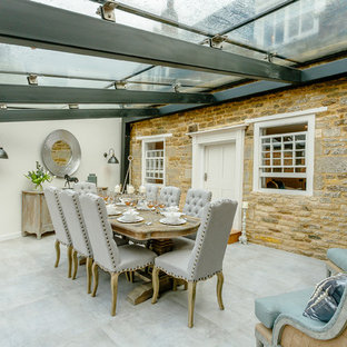 Country dining room in Other with white walls, no fireplace and grey floors.