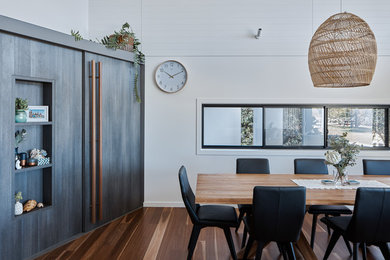 Esempio di una piccola sala da pranzo costiera chiusa con pareti bianche, pavimento in legno massello medio e pavimento marrone