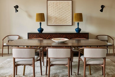 Foto de comedor contemporáneo de tamaño medio cerrado con paredes beige, suelo de madera clara y suelo marrón