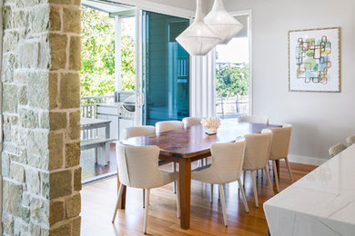 Idées déco pour une salle à manger ouverte sur la cuisine contemporaine avec un mur gris, un sol en bois brun et un sol marron.