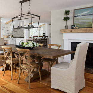 Diseño de comedor de cocina de estilo de casa de campo, de tamaño medio, con paredes beige, suelo de madera en tonos medios, chimenea tradicional, marco de chimenea de yeso y suelo marrón