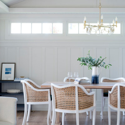 Beach style medium tone wood floor and brown floor dining room photo in Other with white walls