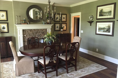 Example of a country dark wood floor dining room design in Atlanta with green walls, a standard fireplace and a stone fireplace