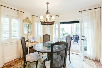 Mid-sized elegant brick floor enclosed dining room photo in Charleston with white walls