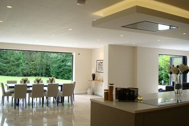 Стильный дизайн: кухня-столовая среднего размера в современном стиле с бежевыми стенами и полом из керамической плитки - последний тренд