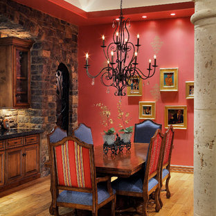 Dining room - mediterranean medium tone wood floor dining room idea in Phoenix with red walls