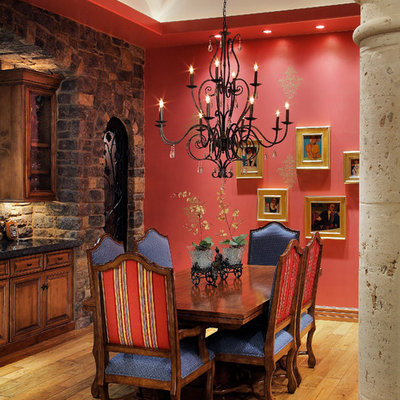 Dining room - mediterranean medium tone wood floor dining room idea in Phoenix with red walls