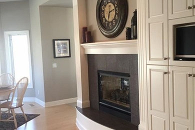 Mid-sized elegant light wood floor great room photo in Minneapolis with gray walls, a standard fireplace and a tile fireplace