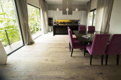 Mittelgroße Wohnküche ohne Kamin mit braunem Holzboden und beiger Wandfarbe in Miami