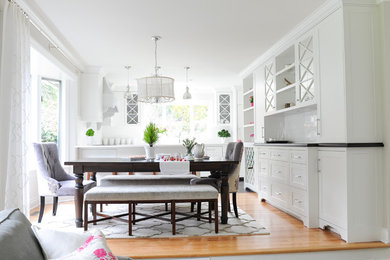 Стильный дизайн: кухня-столовая среднего размера в стиле неоклассика (современная классика) с серыми стенами, паркетным полом среднего тона, стандартным камином и фасадом камина из камня - последний тренд