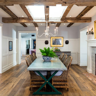 Ispirazione per una sala da pranzo country chiusa con pareti multicolore, pavimento in legno massello medio, camino classico, cornice del camino piastrellata e pavimento marrone
