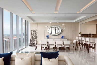 Example of a mid-sized trendy beige floor great room design in Miami with beige walls and no fireplace