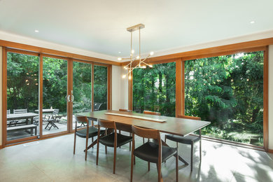 Esempio di una sala da pranzo aperta verso la cucina minimalista di medie dimensioni con pareti bianche e pavimento grigio