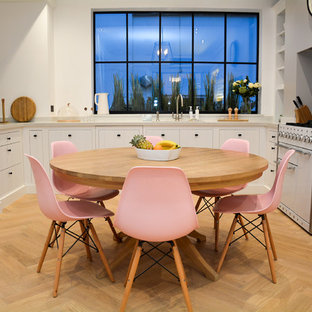 Photo of a medium sized scandi kitchen/dining room in London with light hardwood flooring, white walls and beige floors.