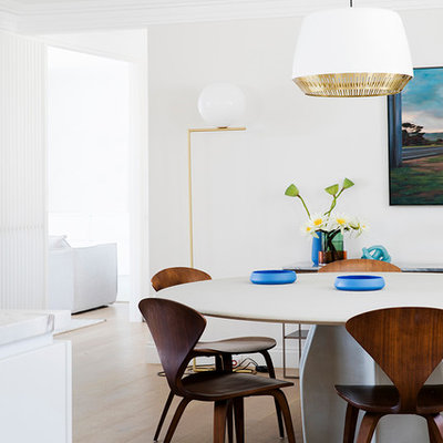 Example of a trendy medium tone wood floor and brown floor dining room design in Sydney with white walls
