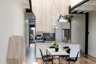 Diseño de comedor de cocina actual con paredes blancas, suelo de madera en tonos medios y suelo marrón