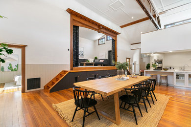 Idee per un'ampia sala da pranzo aperta verso il soggiorno minimal con pareti bianche, pavimento in legno massello medio e pavimento marrone