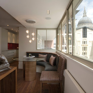 Photo of a medium sized contemporary dining room in London with white walls, medium hardwood flooring and brown floors.