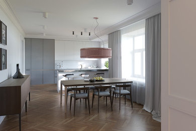Immagine di una sala da pranzo aperta verso la cucina eclettica di medie dimensioni con pareti bianche e pavimento in legno massello medio