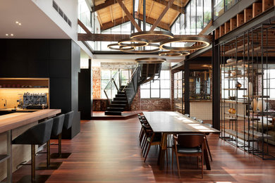 Photo of a large urban open plan dining room in Melbourne with white walls, medium hardwood flooring and brown floors.