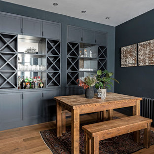 Photo of a contemporary dining room in London with blue walls, medium hardwood flooring and brown floors.