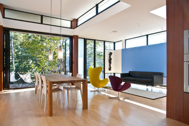 Idee per una sala da pranzo aperta verso il soggiorno minimalista con parquet chiaro