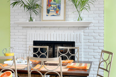 Foto de comedor de cocina costero grande con paredes verdes, suelo de madera en tonos medios, marco de chimenea de ladrillo y todas las chimeneas