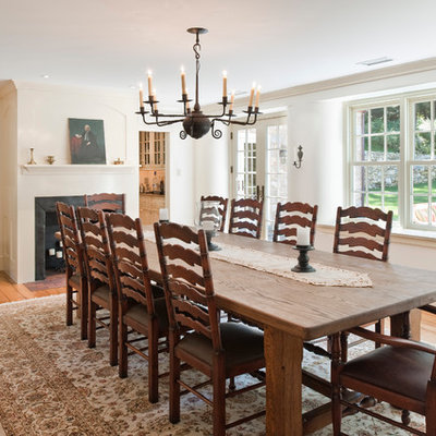Inspiration for a mid-sized farmhouse medium tone wood floor and brown floor enclosed dining room remodel in Philadelphia with a standard fireplace and white walls