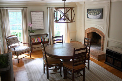 Foto de comedor clásico de tamaño medio abierto con paredes beige, suelo de madera en tonos medios, todas las chimeneas y marco de chimenea de ladrillo