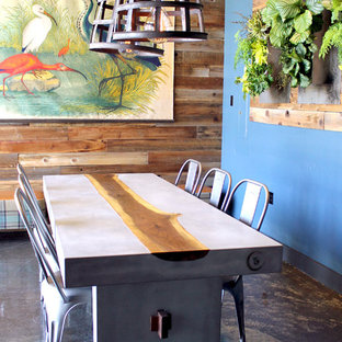 Idee per una sala da pranzo industriale chiusa e di medie dimensioni con pareti blu, pavimento in cemento, nessun camino e pavimento marrone