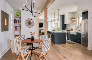 Photo of a large contemporary open plan dining room in Chicago with white walls, medium hardwood flooring, a hanging fireplace, a brick fireplace surround and tongue and groove walls.