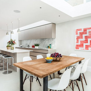 Photo of a contemporary kitchen/dining room in London with white walls, white floors and porcelain flooring.