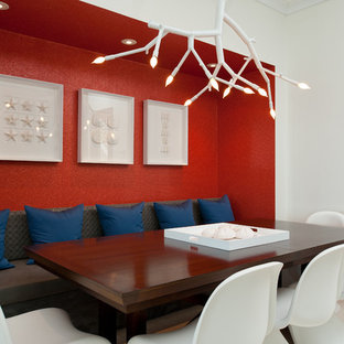 Inspiration pour une salle à manger design avec un mur rouge.