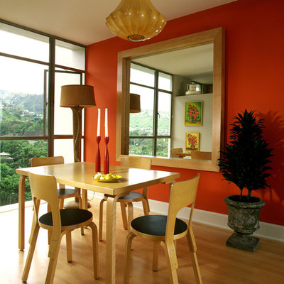 Example of a trendy medium tone wood floor dining room design in Hawaii with red walls