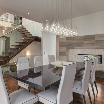 Contemporary Dining Room with Two-Way Fireplace and Custom Stair