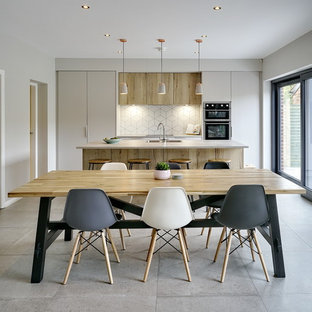 Medium sized contemporary open plan dining room in Belfast with grey floors and beige walls.