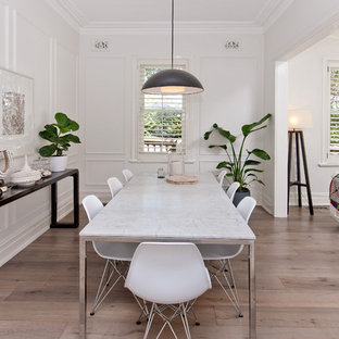 Exemple d'une salle à manger ouverte sur le salon scandinave de taille moyenne avec un mur blanc, sol en stratifié et un sol gris.