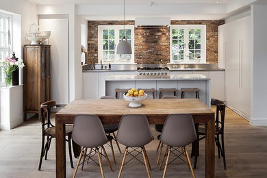 На фото: кухня-столовая среднего размера в стиле кантри с паркетным полом среднего тона, белыми стенами и коричневым полом