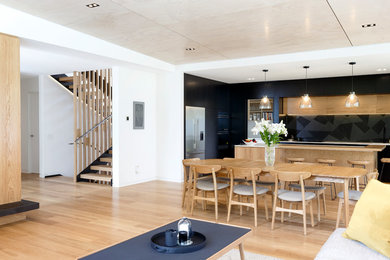 Example of a mid-sized trendy light wood floor and brown floor great room design in Other with white walls