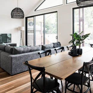 This is an example of a large contemporary open plan dining in Sydney with white walls and medium hardwood floors.