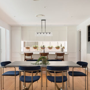 Inspiration for a contemporary dining room in Brisbane with white walls, medium hardwood floors and brown floor.