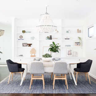 Beach style dining room in Sydney with white walls, dark hardwood floors and brown floor.