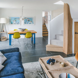 This is an example of a medium sized coastal open plan dining room in Other with white walls, no fireplace and grey floors.