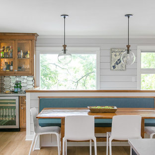 Cette image montre une salle à manger ouverte sur la cuisine rustique de taille moyenne avec un sol en linoléum, un sol marron et un mur gris.