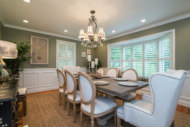 Example of a cottage medium tone wood floor enclosed dining room design in DC Metro with green walls and no fireplace