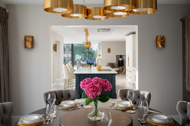 This is an example of a large contemporary open plan dining room in London with grey walls, limestone flooring and white floors.