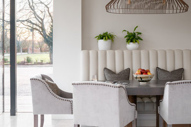 Photo of a large contemporary open plan dining room in London with grey walls, limestone flooring and white floors.