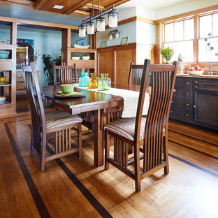 Cette image montre une salle à manger craftsman fermée et de taille moyenne avec un mur blanc et un sol en bois brun.