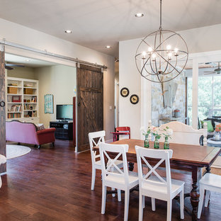Immagine di una sala da pranzo aperta verso la cucina american style con pareti beige, pavimento in legno massello medio e nessun camino